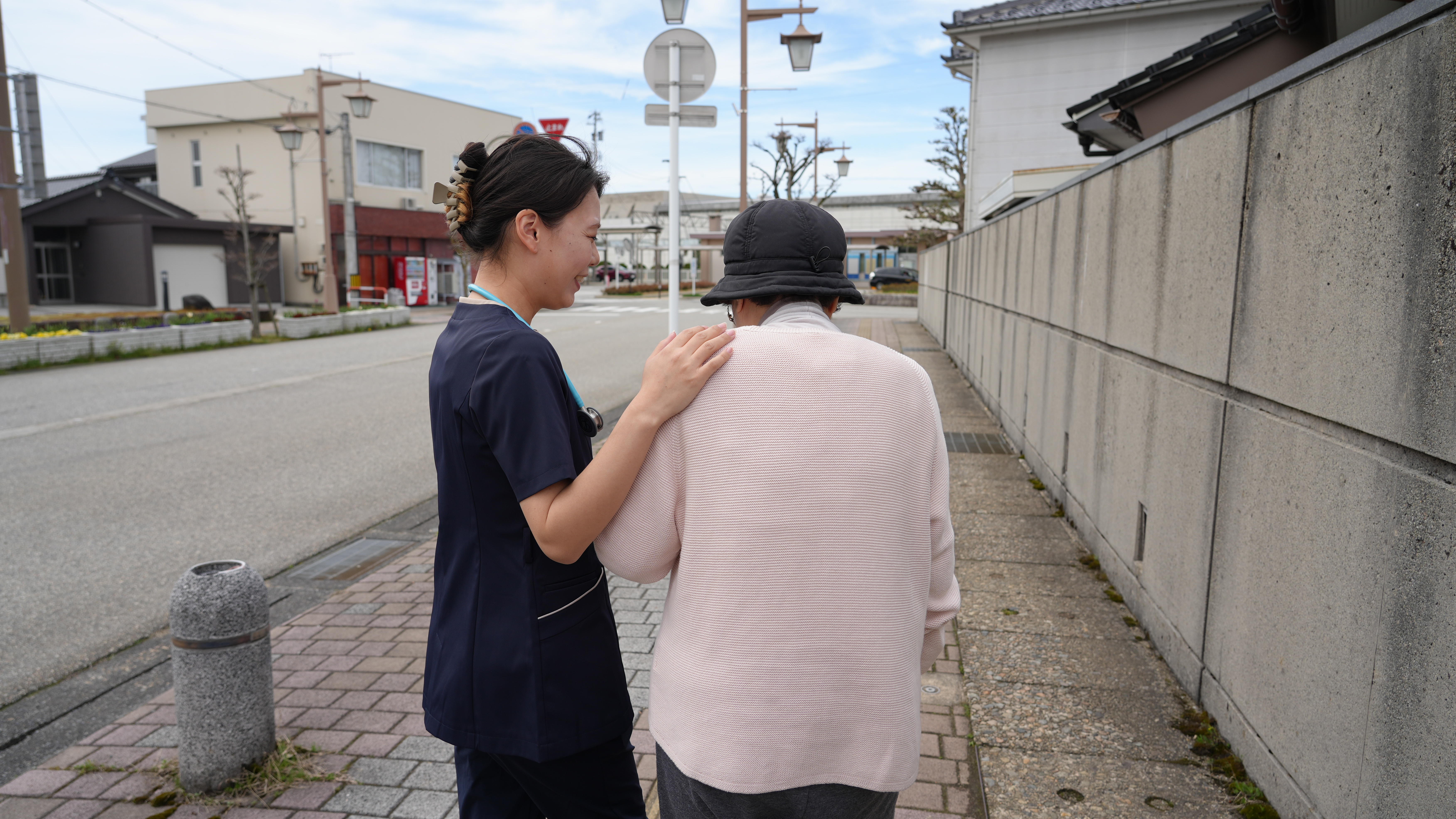 利用者に寄り添いながら外を歩く訪問看護師